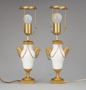 A pair of French circa 1800 gilt bronze and porcelain table lamps.