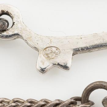 Necklace with graduated cultured pearls, with a clasp in 18K white gold set with an emerald.