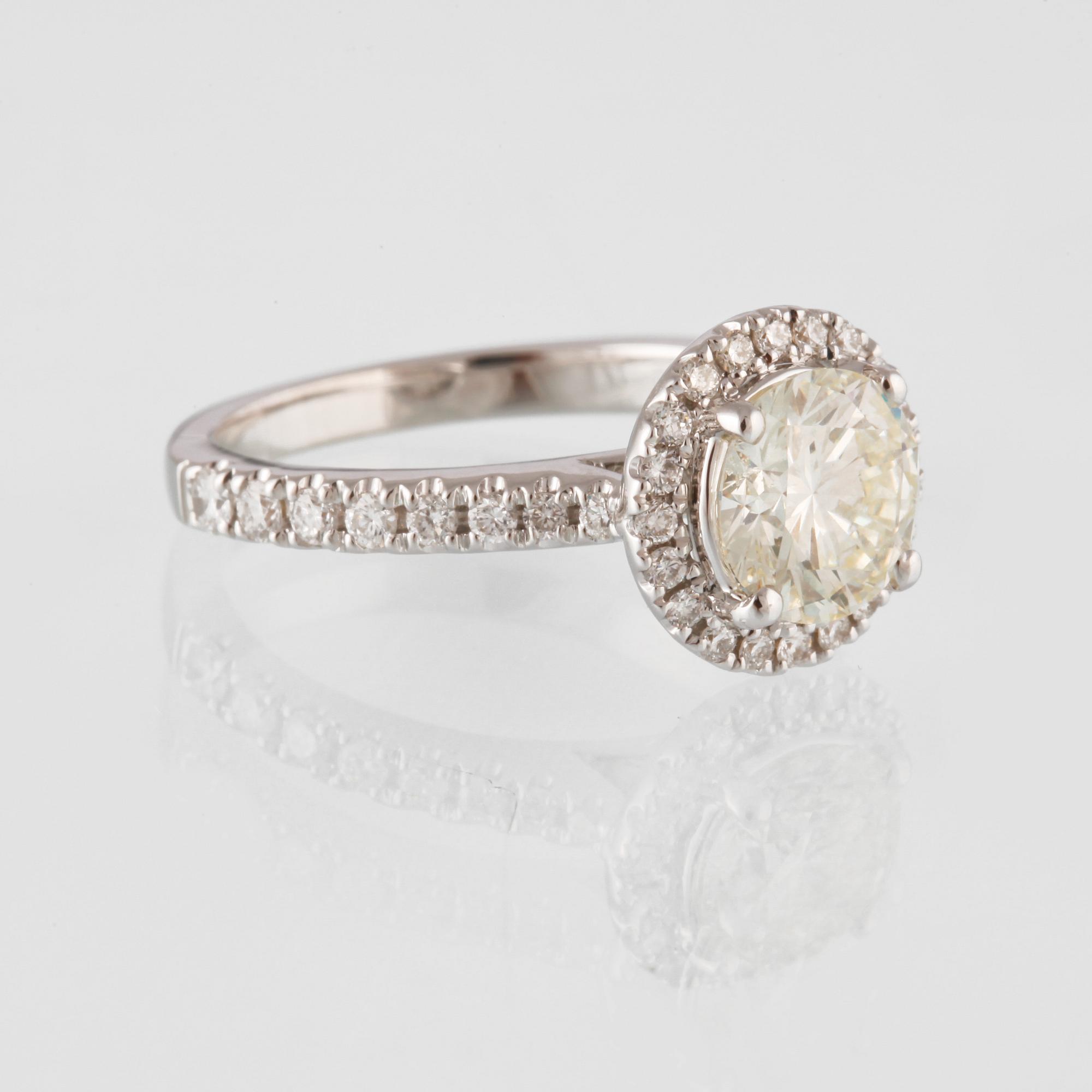 RING, 18K vitguld med en briljantslipad diamant 1.44 ct samt små briljantslipade diamanter 0.50 ct. Vikt 4,6 gram.