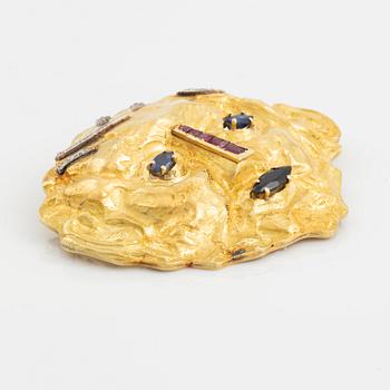 An 18K gold brooch set with diamonds and colored stones.