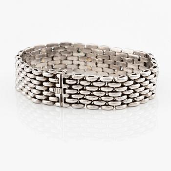 An 18K gold bracelet  with cabochon-cut emeralds and round brilliant- and eight-cut diamonds.