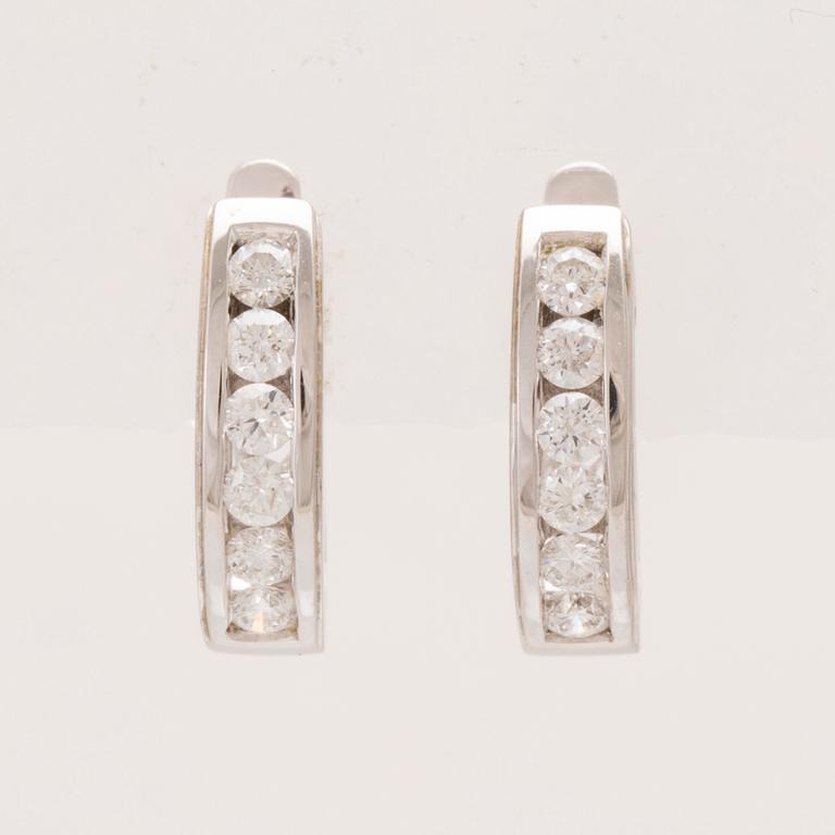 A pair of 18K white gold earrings set with round brilliant-cut diamonds.