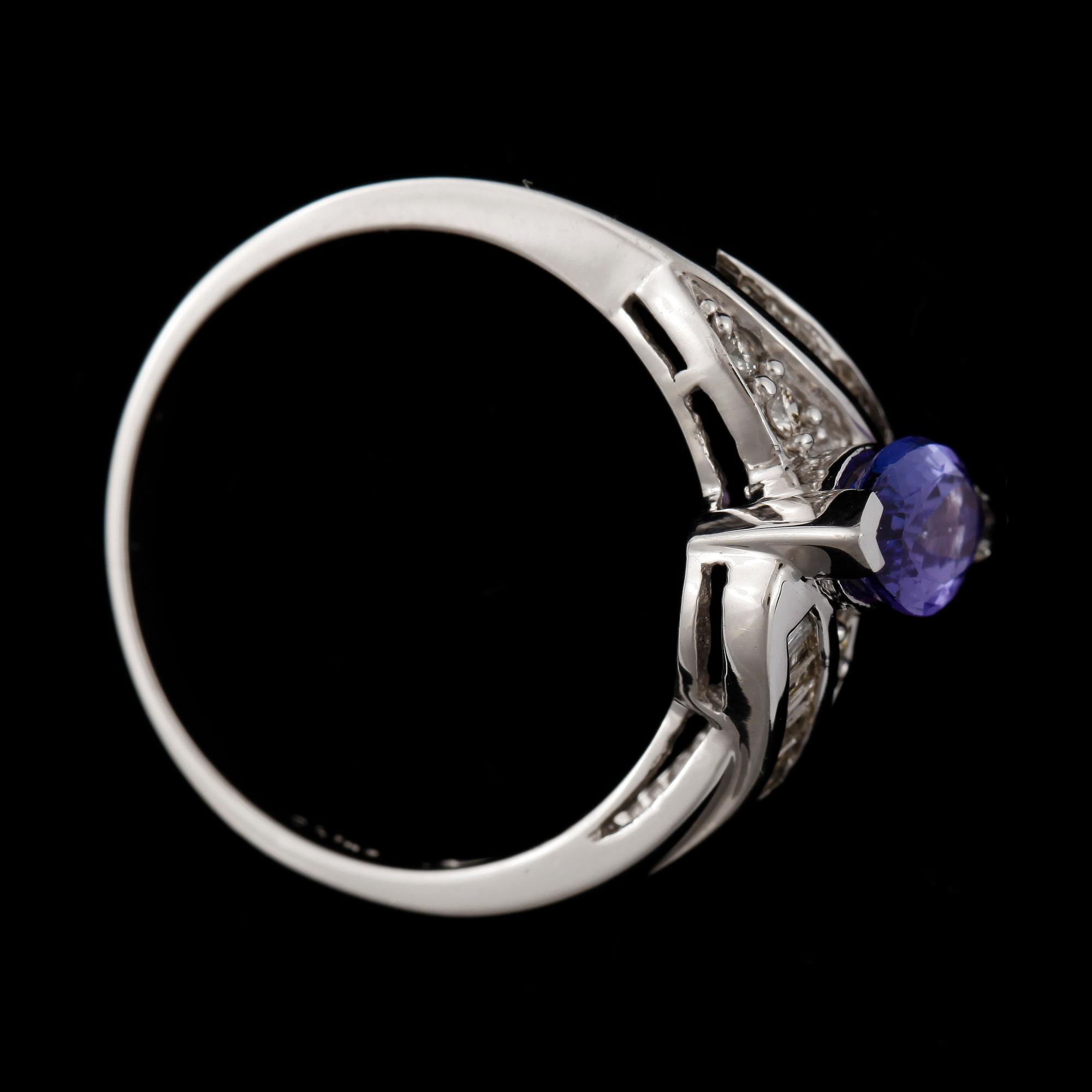 RING, 14k guld med navettslipad tanzanit och 4 briljant- samt 16 baguettslipade diamanter. Vikt ca 4,4 gram.