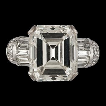 An emerald cut diamond ring, 6.38 cts and smaller baguette- and brilliant cut diamonds.