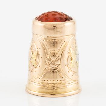 An 18K gold and carnelian thimble.