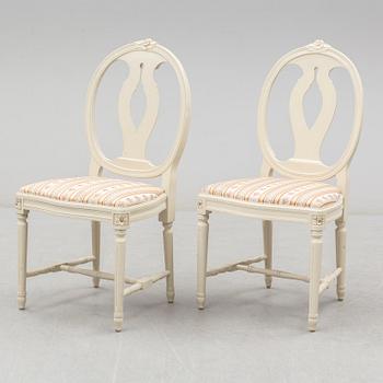 A set of eight chairs and a dining table. Gustavian style, second half of the 20th century. 2 leaves included.