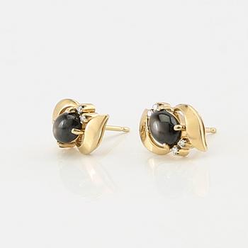 Ring and earrings in 14K gold with round brilliant-cut diamonds and likely natural black star sapphires.