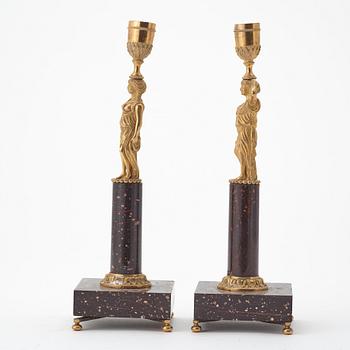 A pair of late gustavian early 19th century porphyry and ormolu candlesticks.