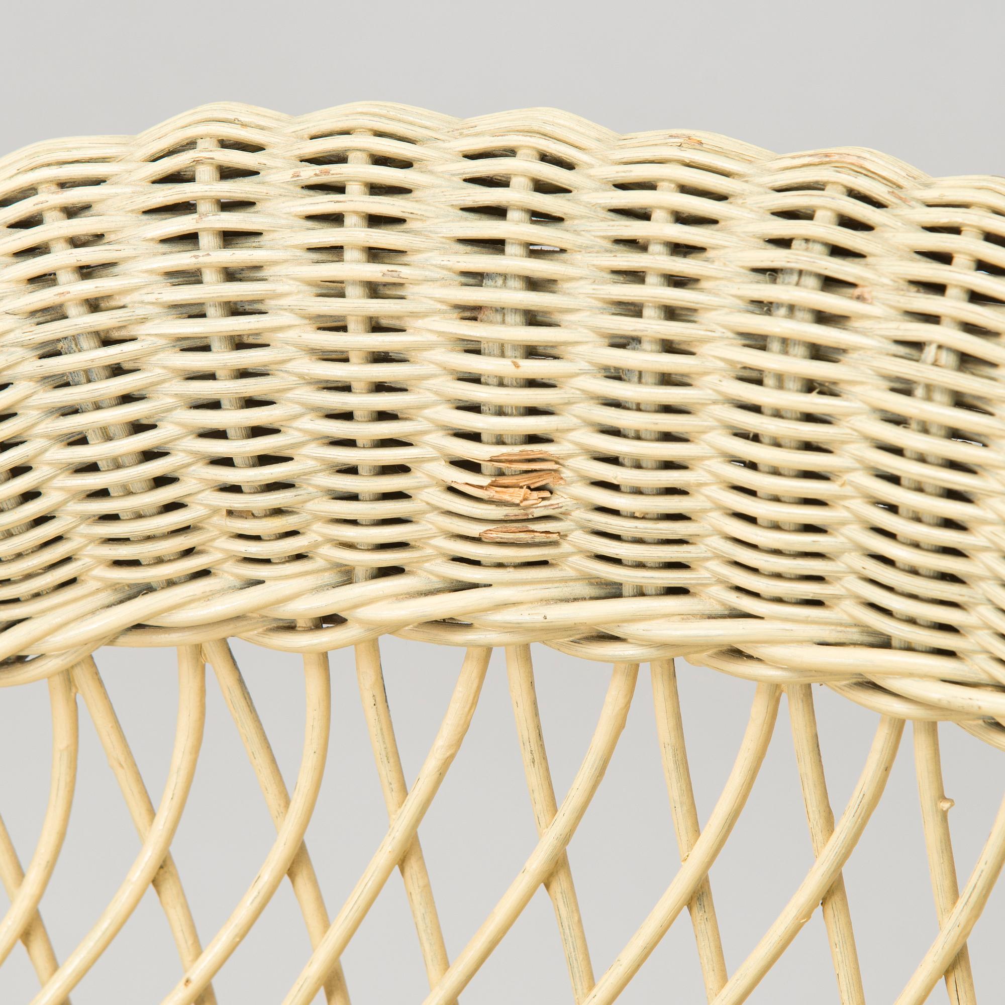 A mid-20th-century three-piece rattan furniture set including two armchairs, and a table.