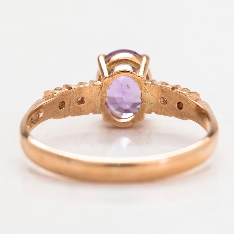 Ring, 14K guld, med en lila-rosa safir och diamanter tot. ca 0.07 ct. Kultakeskus, Tavastehus 1998.