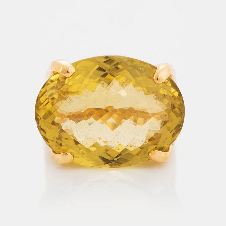 An 18K gold ring set with a faceted lemon quartz.