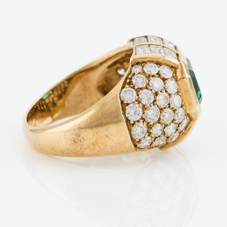 An 18K gold ring with an emerald-cut emerald and baguette and round brilliant-cut diamonds.