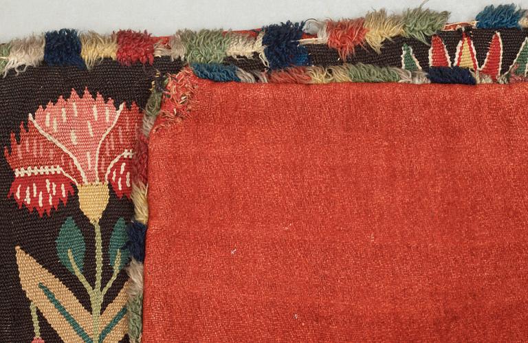 CARRIAGE CUSHION, tapestry weave. "Flower cushion with stylized vases and people". 47 x 101 cm. South of Scania, Sweden, the second half of the 18th century til early 19th century. Probably Torna district.