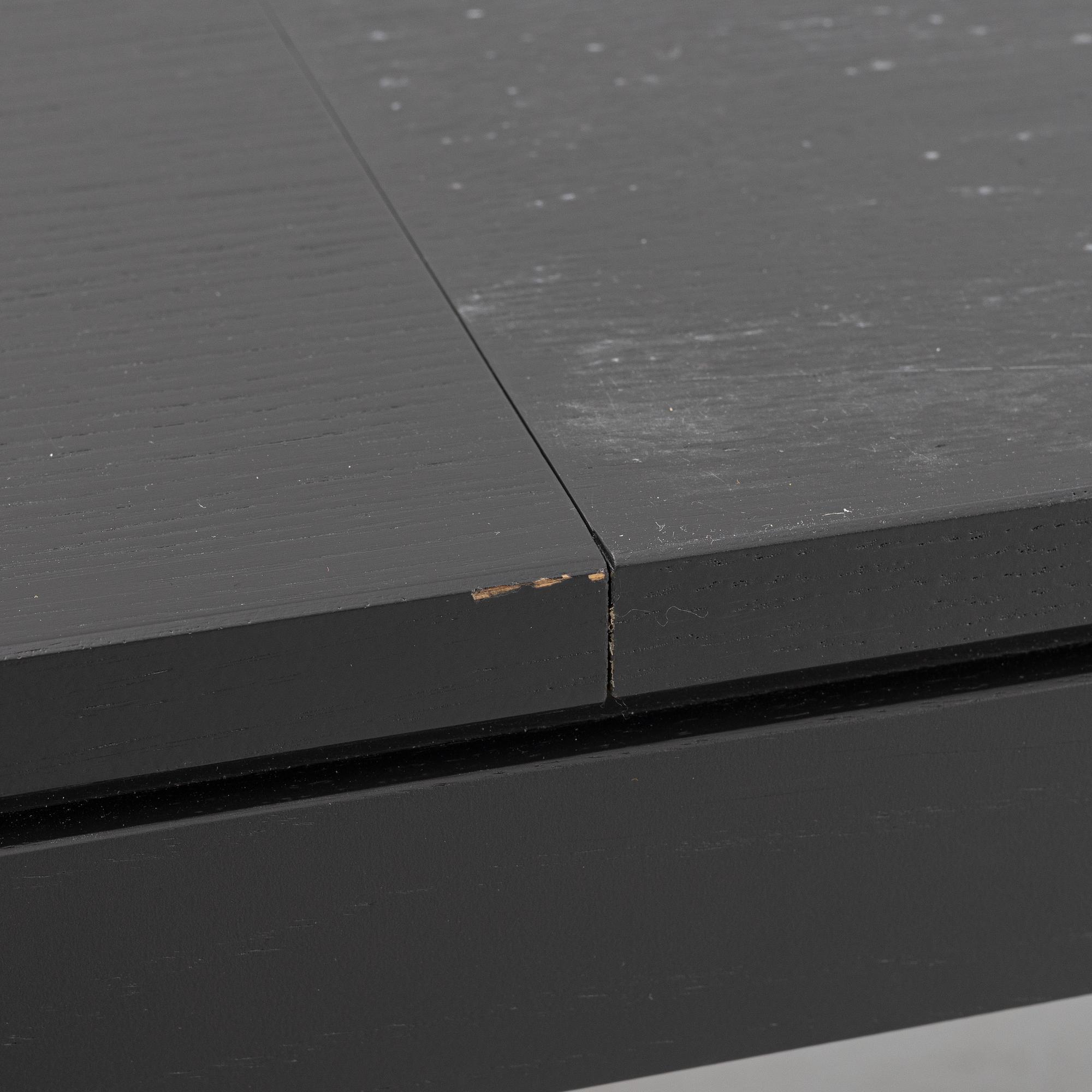 A black oak dining table with two additional leaves.