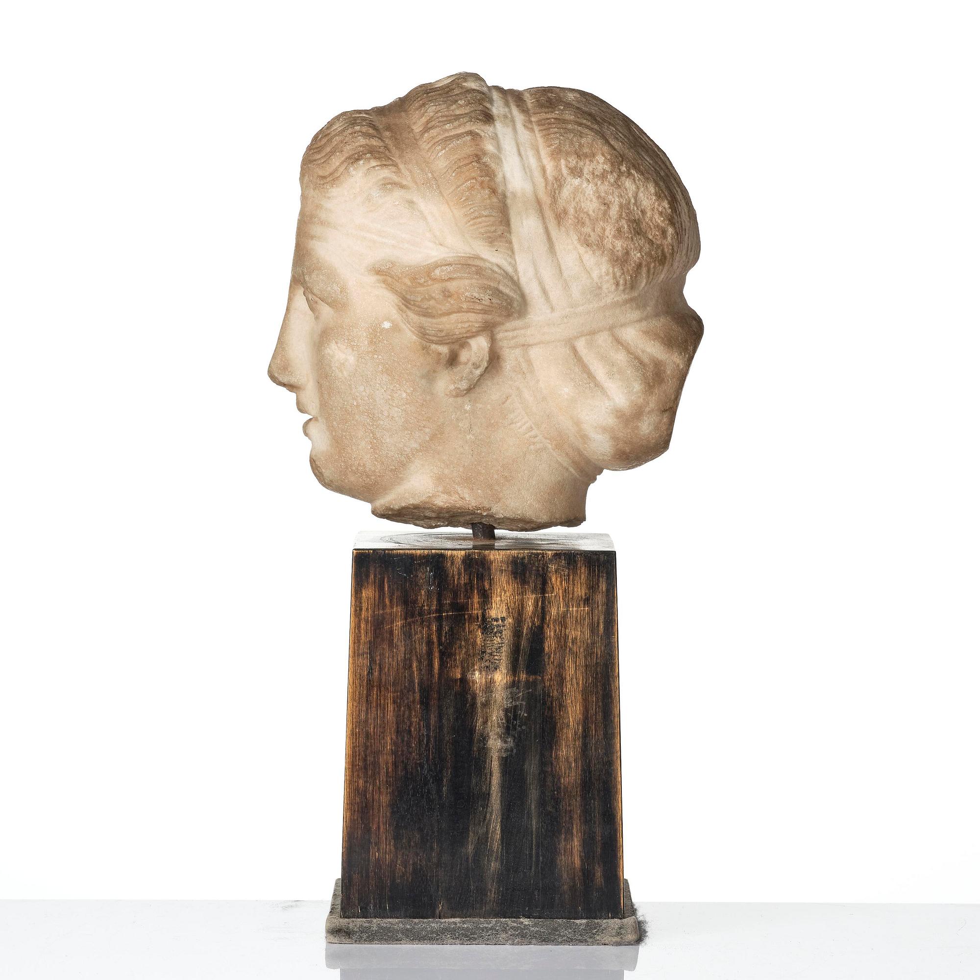 A Greek marble head of a deity wearing a Dionysiac fillet, Hellenistic style presumably 16th century.