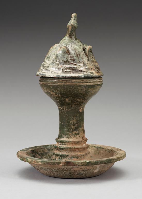 A green glazed pottery Hill Jar, cover with bird shaped finial, Han dynasty (206 BC-AD 220).
