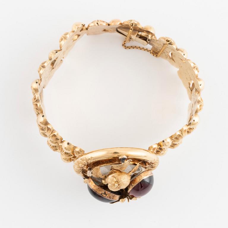 An 18K gold bracelet set with cabochon-cut garnets.