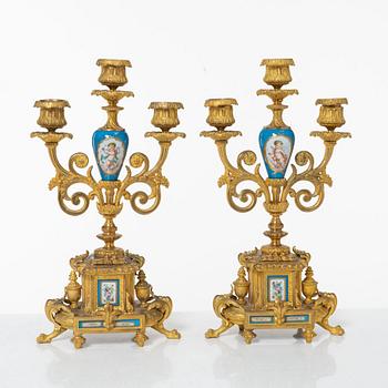A French Louis XVI-style mantel clock and a pair of candelabra, late 19th Century.