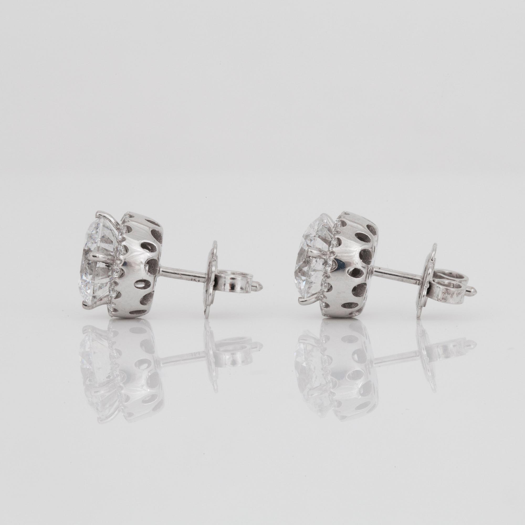 A pair of brilliant-cut diamond earrings. 2.07 cts and 2.11 cts, D-E/SI2, according to certificates from HRD and IGI.