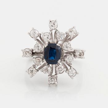 An 18K white gold ring set with a faceted sapphire and old-cut diamonds.