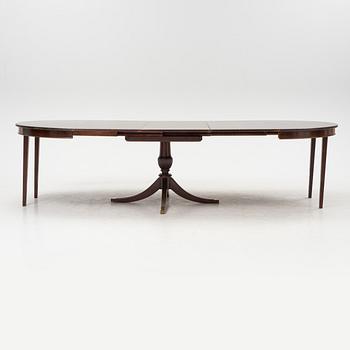 A round mahogany dining table with three additional leaves.