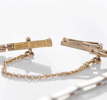 An 18K gold and platinum bracelet set with step-cut rubies and old- and rose-cut diamonds.