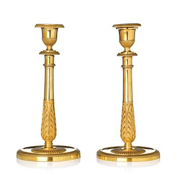 153. A pair of French Empire ormolu and patinated candlesticks in the manner of Claude Galle, Paris, early 19th century.