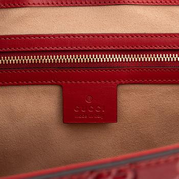 Gucci, a red, embossed leather handbag.