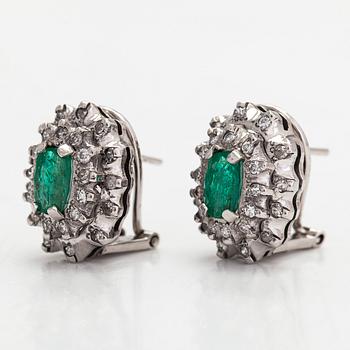 A pair of 14K whitegold earrings set with emeralds and diamonds.