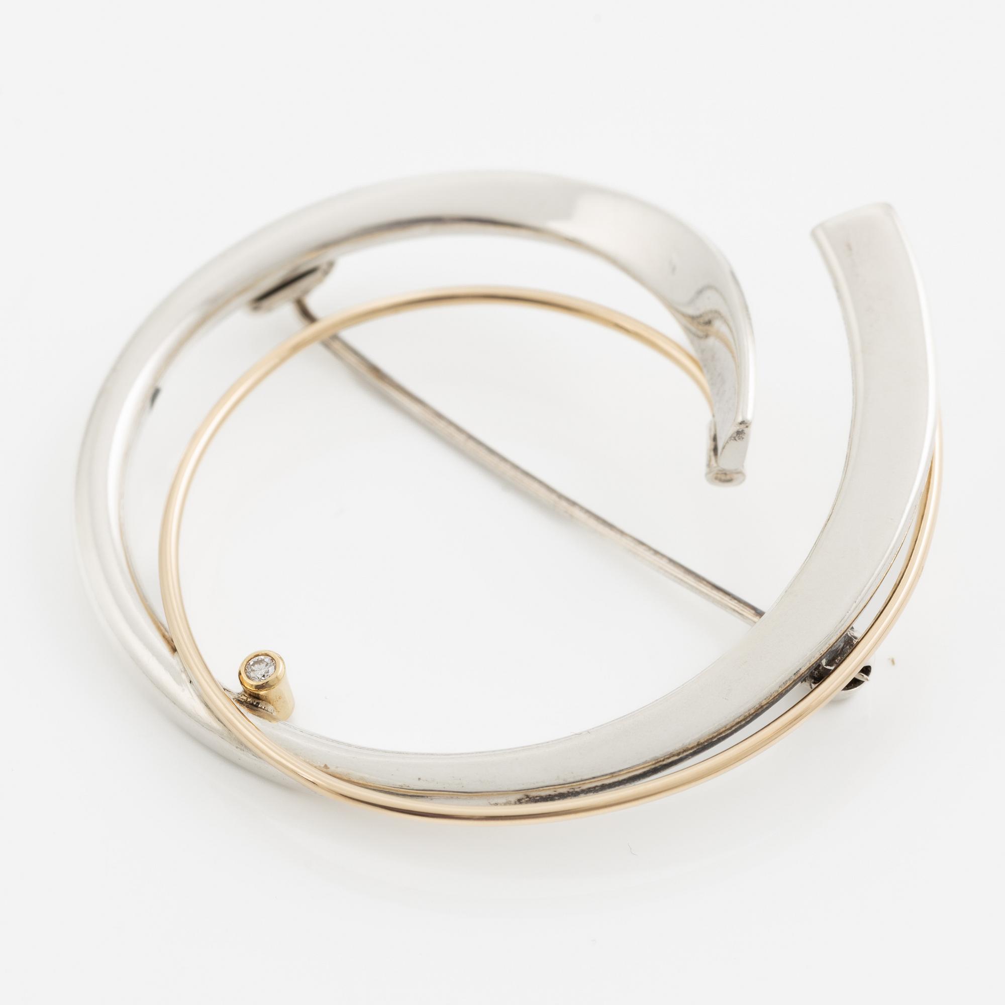 Brosch silver med en rund briljantslipad diamant.