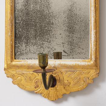 A matched pair of rococo giltwood one-branch girandole mirrors, Stockholm, late 18th century.