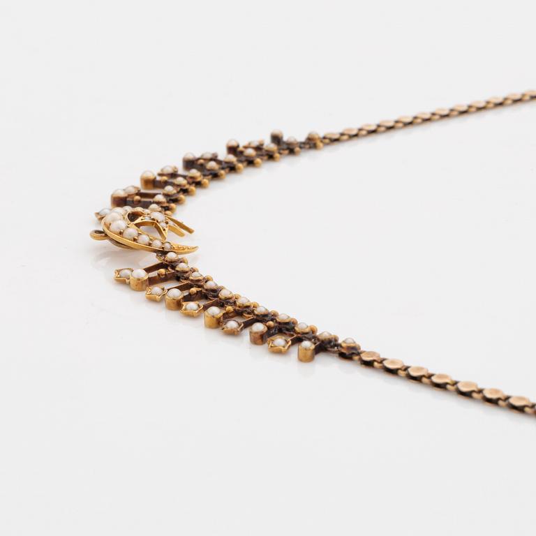 A gold necklace set with pearls.