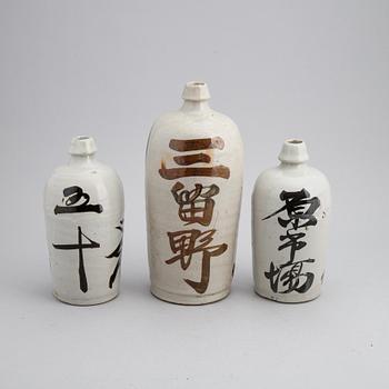 A group of twelve Japanese white glazed ceramic sake bottles, first half of the 20th century and mid 20th century.