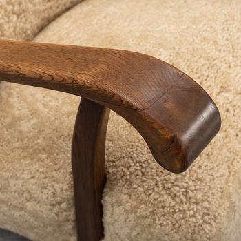 A pair of Danish lounge chairs with sheepskin upholstery.
