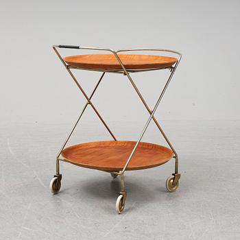 A drinks trolley from J-H Fabrikerna, Sävsjö, 1960-tal.Två lösa, runda brickor fanerade med teak. Märkta J-H Fabrikerna.