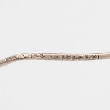 An 18K white gold brooch set with round brilliant-cut diamonds.