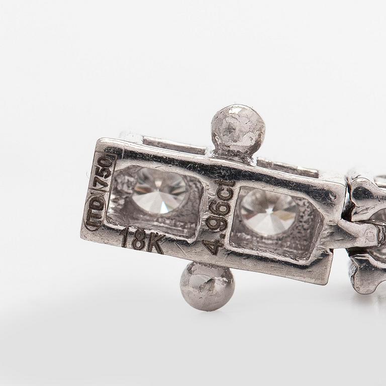 An 18K white gold tennis bracelet, with brilliant-cut diamonds.