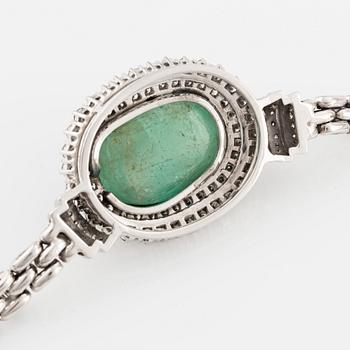 An 18K white gold necklace with a cabochon-cut emerald and round brilliant-cut diamonds.