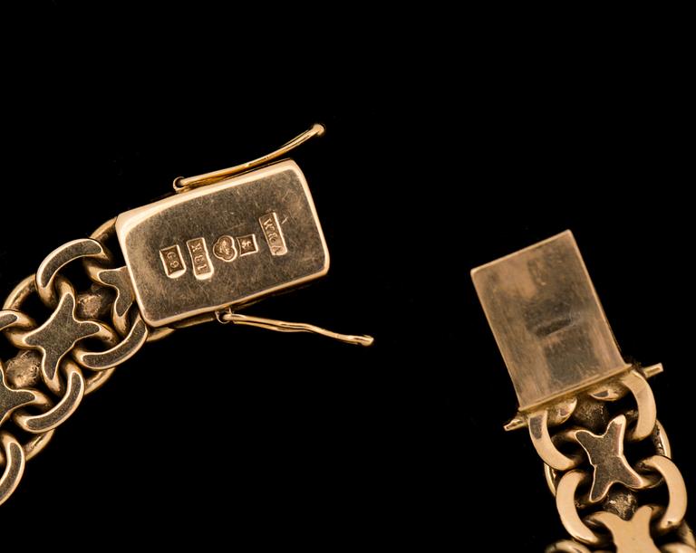 ARMLÄNK, 18 k guld med berlock i form av ett mynt. Vikt ca 34 g.