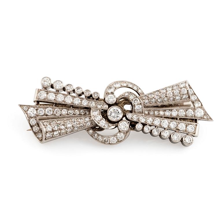 A bow brooch/double clip in 18K white gold set with round brilliant- and eight-cut diamonds.