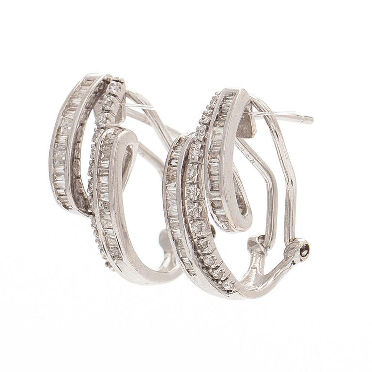 A pair of 18K white gold earrings, set with brilliant- and baguette-cut diamonds.