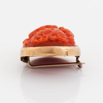 A 14K gold and coral cameo brooch.