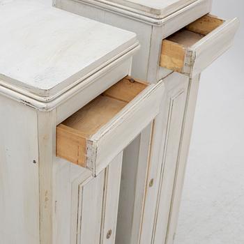 A pair of painted cabinets with a drawer.