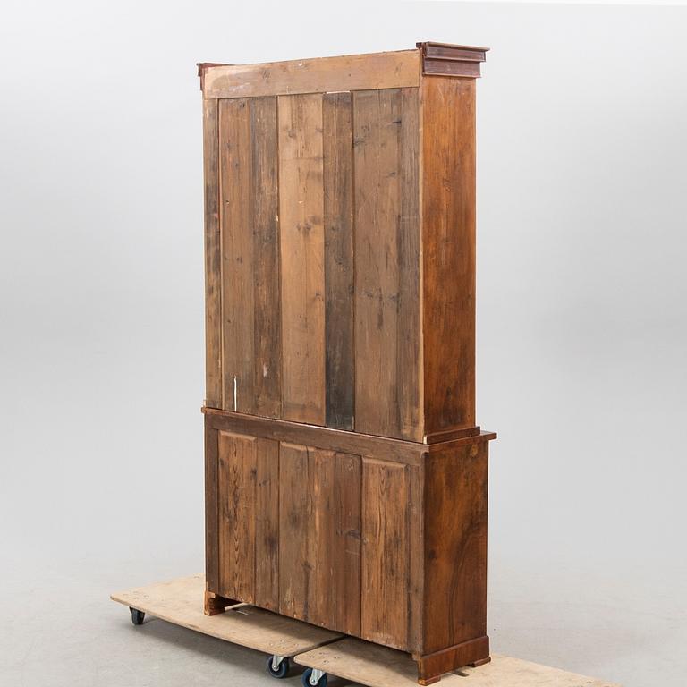 A stained walnut cabinet from the first half of the 20th century.