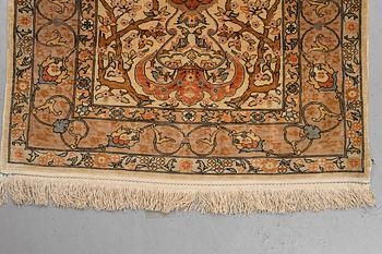 A rug, old silk Hereke, signed, ca 84,5 x 66 cm.