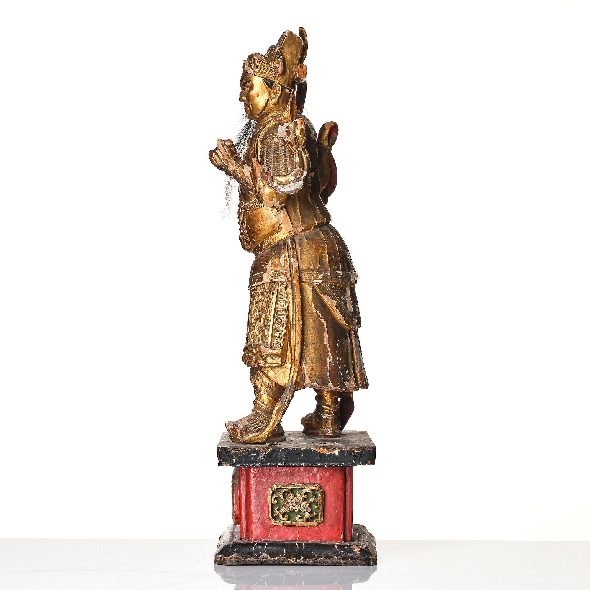A gilt and lacquered standing figure of a guardsman, Qing dynasty.