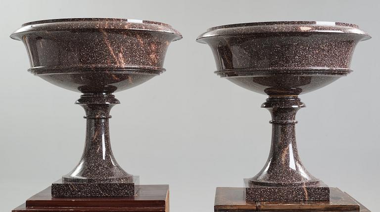 A pair of Swedish porpyry vases on wooden bases, Älvdalen, first half of the 19th century.
