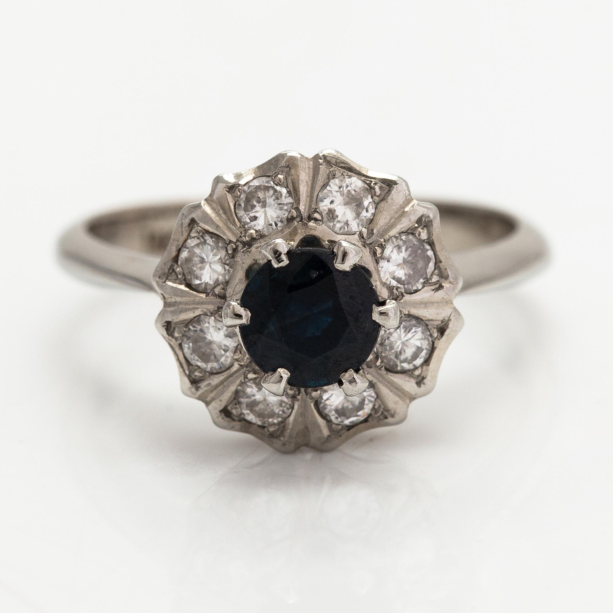 An 18K white gold ring with diamonds ca. 0.24 ct in total and a sapphire. Finnish import marks.