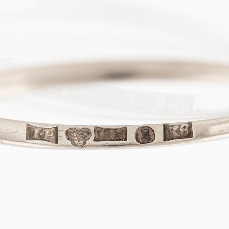 An 18K white gold ring set with a round brilliant-cut diamond.