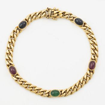 Bracelet in 18K gold set with cabochon-cut emeralds, rubies, and sapphires.